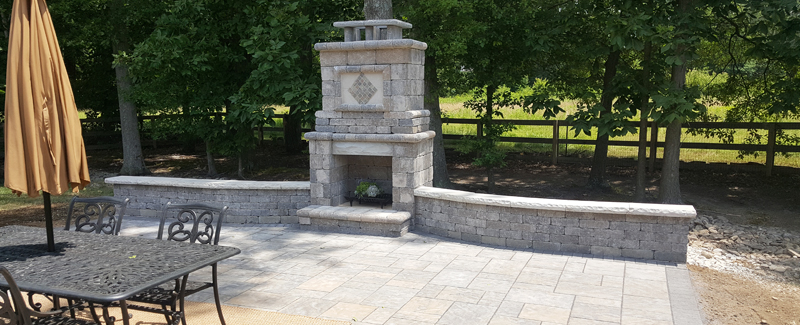 A backyard fire pit with seating walls and columns.